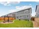 The backyard includes a gas grill, pergola with chairs and grass at 715 N Amory St, Watkins, CO 80137
