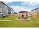 Large backyard with a well-maintained lawn, wooden fence, and a pergola covered seating area at 715 N Amory St, Watkins, CO 80137
