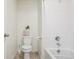 Clean bathroom with a shower-tub combo, white tile, and modern toilet at 715 N Amory St, Watkins, CO 80137