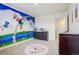 Bright bedroom features a colorful mural and soft carpet at 715 N Amory St, Watkins, CO 80137