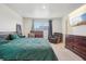 Comfortable main bedroom featuring a large bed, dresser, recliner, and natural light at 715 N Amory St, Watkins, CO 80137