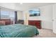 Well-lit main bedroom featuring a large bed, dresser, recliner, and modern decor at 715 N Amory St, Watkins, CO 80137