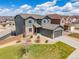 Aerial view of a two-story home with a gray exterior, stone accents, manicured lawn, and a two-car garage at 880 Mcmurdo Cir, Castle Rock, CO 80108
