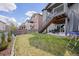 Grassy backyard with a covered patio, stairs to the deck, and a privacy fence at 880 Mcmurdo Cir, Castle Rock, CO 80108