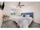 Bright bedroom with a blue headboard, ceiling fan and plenty of natural light from the window at 880 Mcmurdo Cir, Castle Rock, CO 80108