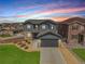 Charming two-story home with a gray exterior, stone accents, manicured lawn, and a two-car garage at 880 Mcmurdo Cir, Castle Rock, CO 80108