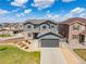 Charming two-story home with a gray exterior, stone accents, manicured lawn, and a two-car garage at 880 Mcmurdo Cir, Castle Rock, CO 80108