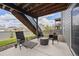 Covered patio with outdoor seating underneath a wood deck and stairs to backyard at 880 Mcmurdo Cir, Castle Rock, CO 80108