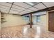 View of the basement with light wood floors and exposed wood column with wood burning stove and built in shelves at 30839 Manitoba Dr, Evergreen, CO 80439