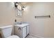 A quaint bathroom with a white vanity, decorative mirror, and sconce lighting adding a cozy, personal touch at 30839 Manitoba Dr, Evergreen, CO 80439