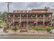 Multi-story commercial building with wooden balconies, adorned with American flags and decorative bear figurines at 30839 Manitoba Dr, Evergreen, CO 80439