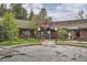 Brick building with a red awning and well-lit entrance, offering retail space in a busy commercial district at 30839 Manitoba Dr, Evergreen, CO 80439