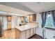 Bright kitchen with wood cabinets, tiled countertops, and an adjacent pantry for storage at 30839 Manitoba Dr, Evergreen, CO 80439
