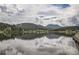 Picturesque view of the lake, and the clouds and trees reflecting in the still water at 30839 Manitoba Dr, Evergreen, CO 80439