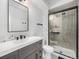 Bathroom boasts gray vanity, mosaic tile accent wall, large mirror, and glass-enclosed tiled shower at 6930 E Girard Ave # 304, Denver, CO 80224