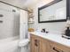 Bathroom features single sink vanity, decorative wall shelves, framed mirror, and tile surround tub and shower at 6930 E Girard Ave # 304, Denver, CO 80224