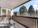 Balcony with patio furniture and views of neighborhood trees and the sky at 6930 E Girard Ave # 304, Denver, CO 80224