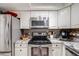 Modern kitchen featuring stainless steel appliances, granite countertops, and white cabinets at 8337 S Upham Way # 103, Littleton, CO 80128