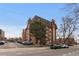 Brick apartment building with unique architectural details and mature tree in a well-maintained landscape at 1008 N Corona St # 405, Denver, CO 80218
