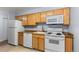 This kitchen features white appliances with light wood cabinets and granite countertops at 1008 N Corona St # 405, Denver, CO 80218
