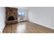Bright living room featuring hardwood floors, a cozy brick fireplace, and a large window with city views at 1008 N Corona St # 405, Denver, CO 80218