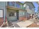 Exterior view of a green townhome with brick accents and a small front porch at 10490 W Jewell Ave # D, Lakewood, CO 80232