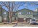 Green townhome exterior with a brown garage door and a vehicle parked in front at 10490 W Jewell Ave # D, Lakewood, CO 80232