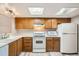 Simple kitchen with wood cabinets, white appliances, and a microwave at 10490 W Jewell Ave # D, Lakewood, CO 80232