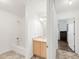 Bright bathroom with white walls, patterned tile floor, vanity and combination shower and bathtub at 1748 Eagle St # B, Aurora, CO 80011