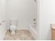 Bathroom featuring a toilet and shower and bathtub combination, patterned tile floor, and white walls at 1748 Eagle St # B, Aurora, CO 80011