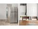 Bright kitchen featuring stainless steel appliances, dining table, and stacked washer and dryer at 1748 Eagle St # B, Aurora, CO 80011