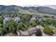 A wide angle aerial showing neighborhood surrounded by green trees and mountains at 573 Entrada Dr, Golden, CO 80401