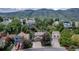 A high angle view of a residential neighborhood surrounded by green trees and mountains at 573 Entrada Dr, Golden, CO 80401