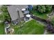 Aerial shot highlighting the backyard with a patio, grilling area, green lawn, play structure, and privacy fence at 573 Entrada Dr, Golden, CO 80401