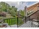 Cozy backyard deck with umbrella and seating that overlooks a green, landscaped backyard at 573 Entrada Dr, Golden, CO 80401