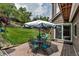 Outdoor patio with seating area, featuring a table with umbrella and lush greenery, ideal for entertaining at 573 Entrada Dr, Golden, CO 80401