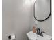 This well-lit half-bath features a pedestal sink, modern faucet and sleek, round mirror at 573 Entrada Dr, Golden, CO 80401