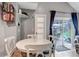 Bright dining area featuring a white table with seating for four, a view of the patio, and hardwood floors at 573 Entrada Dr, Golden, CO 80401