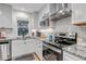 Bright kitchen boasts white cabinets, stainless steel appliances, granite counters and under-cabinet lighting at 573 Entrada Dr, Golden, CO 80401