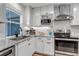 Modern kitchen with white cabinets, stainless steel appliances, granite countertops and a tiled backsplash at 573 Entrada Dr, Golden, CO 80401