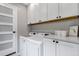 The well-lit laundry room features white cabinets, countertops, and modern washer and dryer at 573 Entrada Dr, Golden, CO 80401