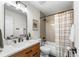 Well-lit bathroom featuring a vanity with modern fixtures and tub with shower at 4043 E Geddes Cir, Centennial, CO 80122