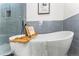 Close-up of modern soaking tub with book tray and accent wall at 4043 E Geddes Cir, Centennial, CO 80122