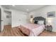 This bedroom boasts modern wood floors, neutral paint, and a stylish pink patterned bedspread at 4043 E Geddes Cir, Centennial, CO 80122