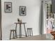 Small dining area features a round table with dark legs and three stools next to a door at 4043 E Geddes Cir, Centennial, CO 80122