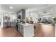 Open concept kitchen features gray cabinets, stainless appliances, white subway tile, floating wood shelves, and wood floor at 4043 E Geddes Cir, Centennial, CO 80122