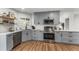 Bright kitchen features grey cabinets, stainless appliances, white subway tile, floating wood shelves and wood floor at 4043 E Geddes Cir, Centennial, CO 80122