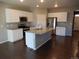 Open kitchen features white cabinets, stainless appliances, granite countertops, and island sink at 4482 S Ukraine Ct, Aurora, CO 80015