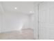 Bright basement features neutral tile flooring and recessed lighting, with an adjacent white paneled door at 11976 E Arizona Dr, Aurora, CO 80012