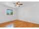 Bedroom featuring hardwood floors, white walls, ceiling fan and a large window at 11976 E Arizona Dr, Aurora, CO 80012
